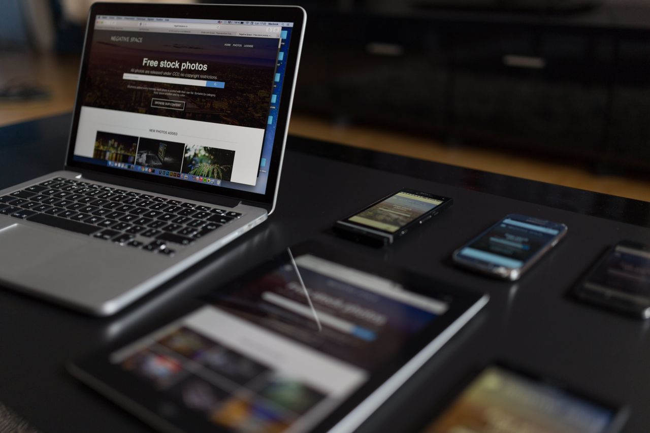 Un espace de travail moderne présentant un ordinateur portable, une tablette et des smartphones, idéal pour les usages technologiques et le travail en freelance.